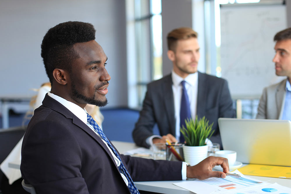 Businessman in a meeting with advisers around a boardroom table